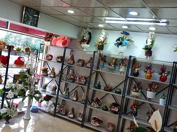 Dükkân içindeki raflarda hediyelik eşyalar, mumluklar ve küçük aranjmanlar