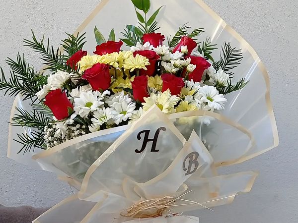 Kırmızı gül ve beyaz papatyaların karışık olduğu buket, krem ambalajlı