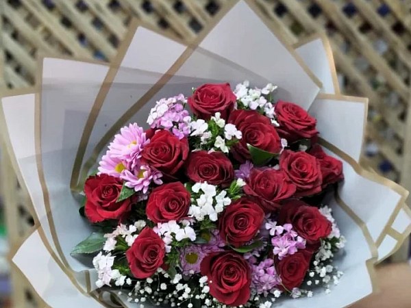 Bordo güller ve pembe kasımpatılardan hazırlanmış buket, krem ambalajlı