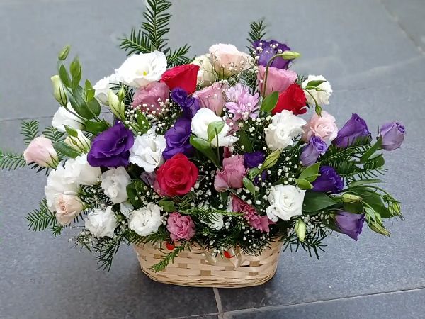 Hasır sepette mor ve pembe lisianthus, beyaz güller ve cipso